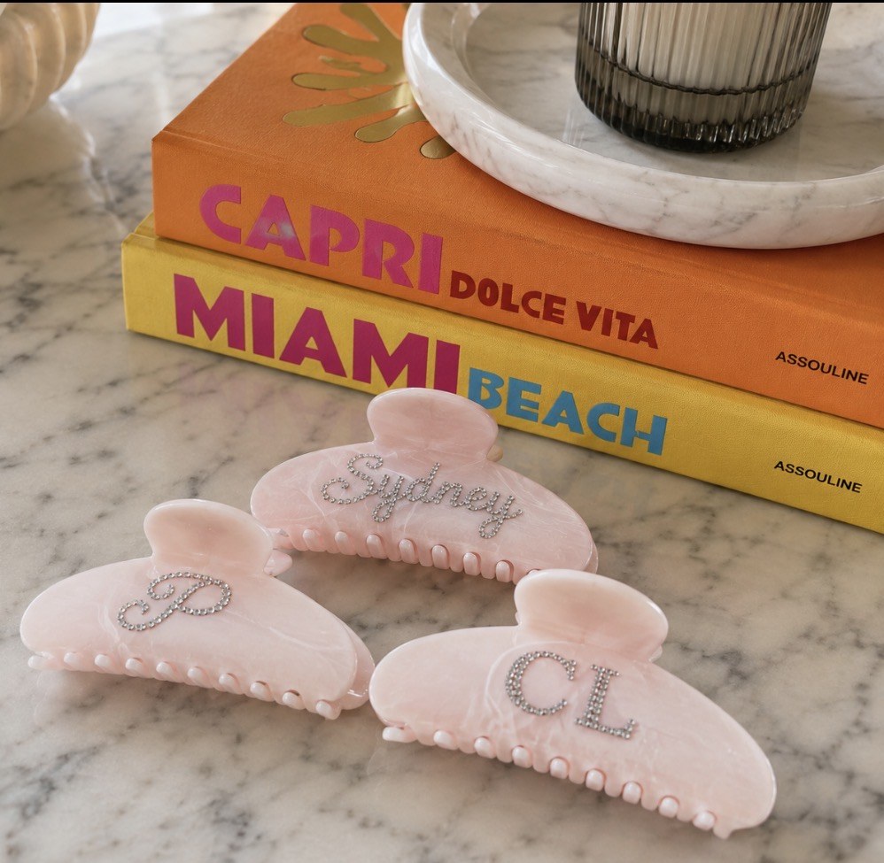Pink personalized clips beside coffee table books
